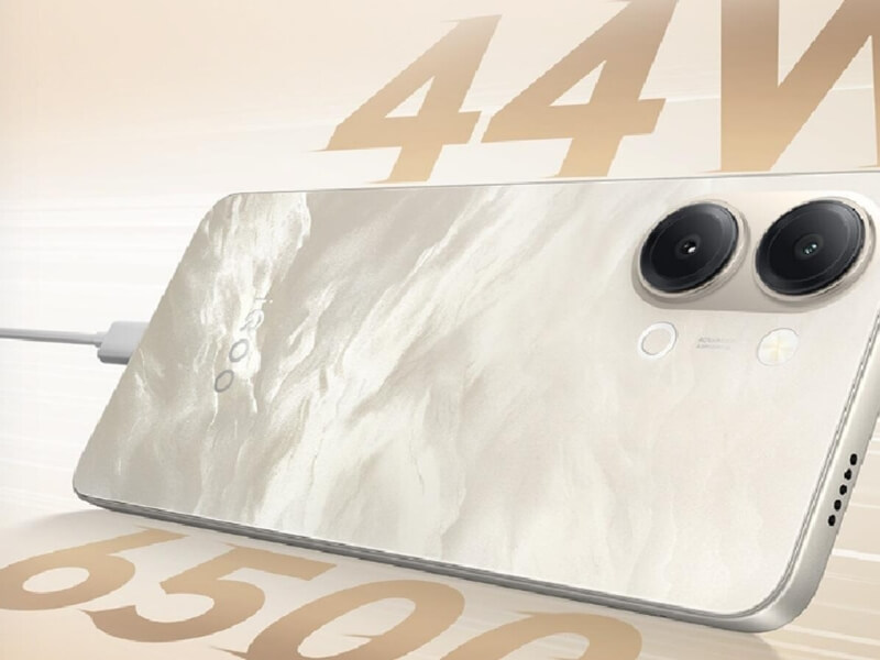 An iQOO smartphone with a beige marble-textured back panel, dual rear camera module, and a plugged-in USB-C charging cable, featuring overlaid text highlighting 44W charging.